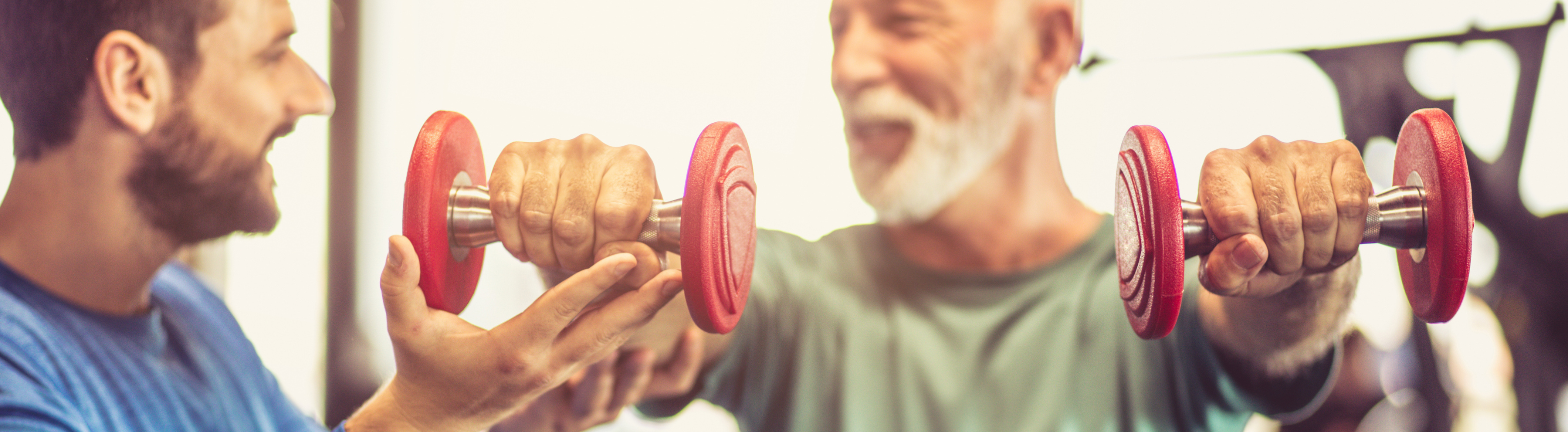 Older adult taking assistance from gym instructor on an excercise